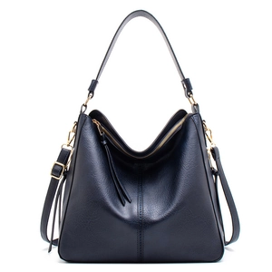 Detail of navy blue leather hobo bag with gold metal hardware and textured finish