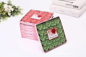 Top view of 50-piece heart-shaped tealight candles set in red and green window gift box