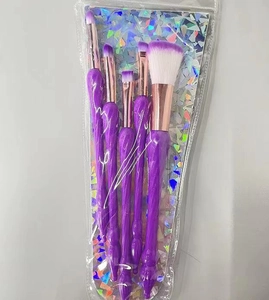 Detail of 5-piece purple makeup brush set with spiral handles and holographic card