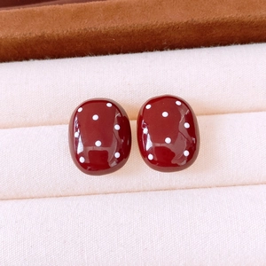 Close-up of vintage oval red earrings with white polka dots in a jewelry box