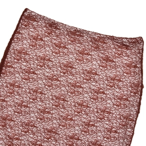 Macro shot showing brown floral lace fabric texture and detailed embroidery pattern