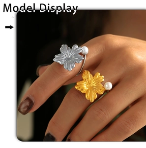 Detailed close-up of gold and silver flower pearl rings on a model's hand