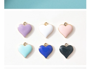 Detailed view of colorful heart-shaped enamel charms with golden metal edges in six colors