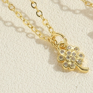 Close-up of golden clover pendant featuring intricate cubic zirconia pavé setting detail