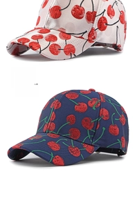 Detail of embroidered cherry patterns on cream and navy blue baseball caps with stitching
