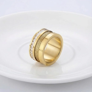 Detailed macro view of a gold wide band ring with steel cable inlay and Roman numerals