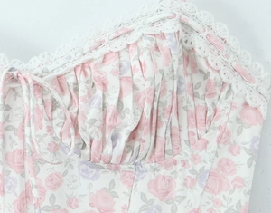 Dettaglio del bustino a fiori con bordo in pizzo e cuciture arricciate sul vestito