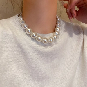 Detail of French vintage gradient pearl necklace worn on neck with white knitwear