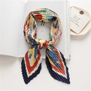 Dettaglio ravvicinato di un foulard plissettato con stampe colorate e seta sintetica