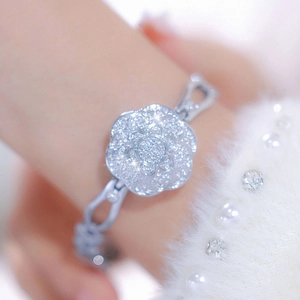 Close-up of a silver camellia bracelet watch with luxury full diamond pavé setting