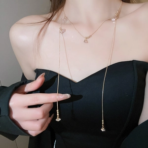 Détail d'un collier doré multicouche avec perles et zircons sur le cou d'un modèle