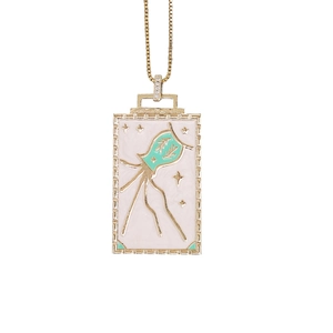 Detail view of rectangular gold pendant with white and green enamel evil eye motif