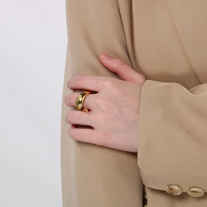 Close-up of 18k gold plated snake ring with diamonds worn on hand with a tan blazer
