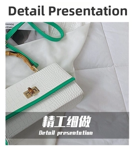 Close-up of white crocodile pattern handbag with green trim and classic bamboo handle