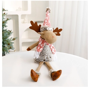 Close-up of knit Christmas reindeer doll with snowflake hat and scarf on a white table