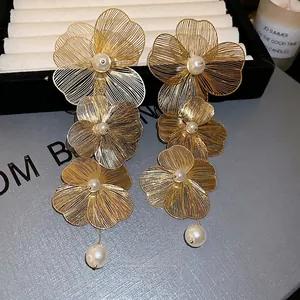 Elegant gold metal flower drop earrings with white pearls and sparkling studs