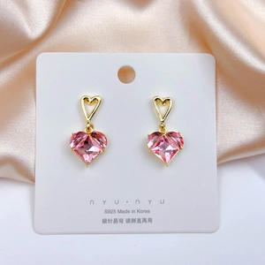 Detail of pink heart-shaped crystal earrings with S925 silver needle on silk background