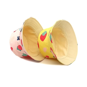 Detail of pink and yellow kids bucket hats with strawberry prints and soft inner lining