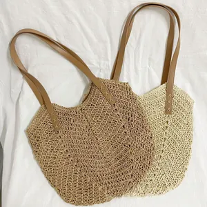 Detailed top view of handmade woven straw beach bags with leather straps in two colors