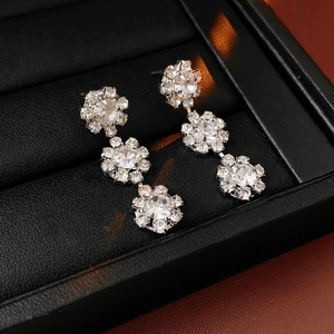 Macro shot of silver sunflower earrings with sparkling diamonds in a luxury jewelry box