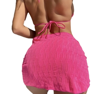 Bright pink backless bikini set and textured wavy jacquard mini skirt on a model