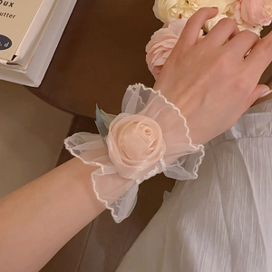 Détail de la rose de poignet en dentelle de maille champagne avec pétales d'organza