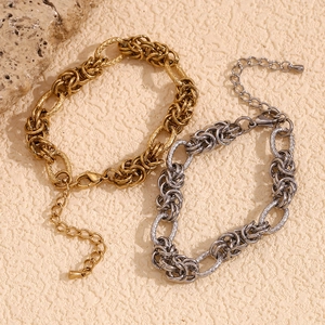 Detailed macro view of chunky gold and silver knot link bracelets on a beige background