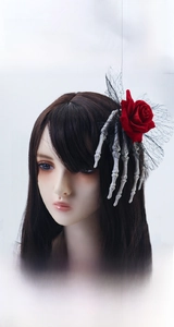 Gothic hair clip detail featuring a red rose, silver skeleton hand and black lace mesh