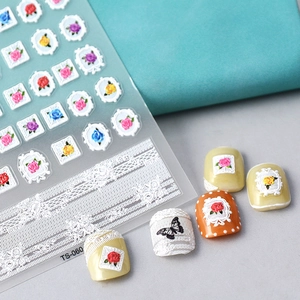 Macro detail of 5D embossed nail stickers featuring rose flowers and white lace frames