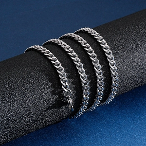 Polished silver stainless steel Cuban link chain necklace on a black cylindrical stand