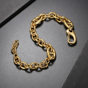 Close-up of golden stainless steel pig nose chain bracelet on a dark textured background