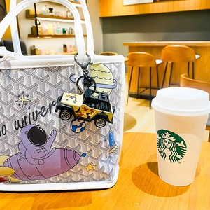 Tote bag with universe astronaut print and camouflage jeep keychain on handle