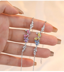 Detail of silver butterfly bracelets with pink and blue zircons on a model's hand