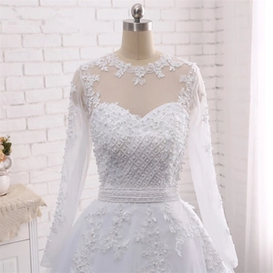 Detailed view of the intricate pearl embroidery and lace floral patches on white bridal gown