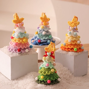 Handmade crochet Christmas tree ornaments in four colors on a white pedestal