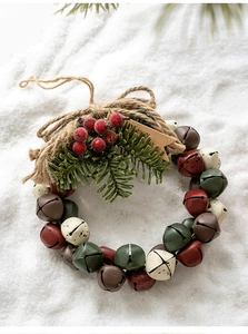 Detailed close-up of Christmas bell wreath with pine needles and red berries on snow