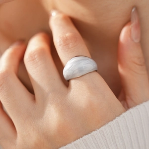 Detail of silver chunky dome ring featuring grey marble enamel inlay on finger