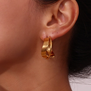 Detailed close-up of 18K gold plated twisted double hoop earrings worn by a model