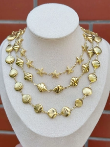 Close-up of 18k gold stainless steel necklace with shell and starfish charms