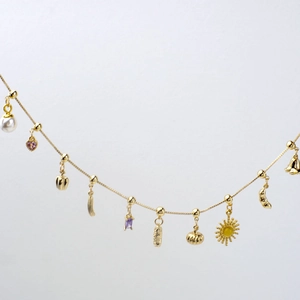 DIY gold link chain bracelet with heart, pearl, and colorful gemstone pendants