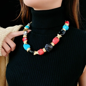 Detail of vintage necklace with colorful irregular stone beads and gold metal links