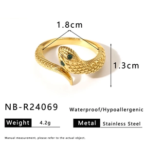 Detail of snake ring with green zircon eyes, gold finish, and scale texture details