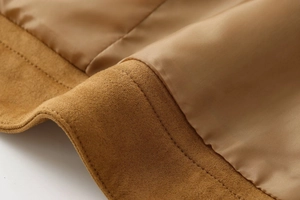 Close-up of camel suede jacket showing fine stitching and smooth satin lining detail