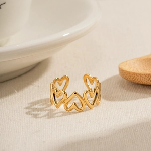 Minimalist gold heart cutout open ring with a polished mirror finish on a warm texture