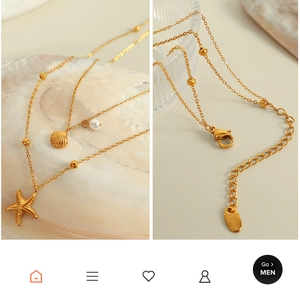 Macro detail of starfish and shell pendants on a 18K gold-plated stainless steel chain