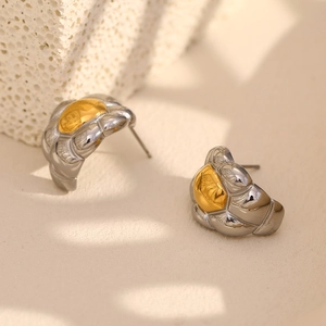 Two-tone 18K gold plated stainless steel stud earrings with woven texture on stone background