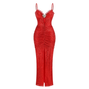 Detail of red sequin dress featuring heart brooch, V-neckline and ruching