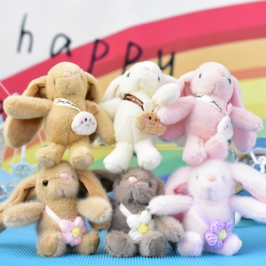 Detail view of various colorful plush rabbit keychains with cute flower and bag accessories