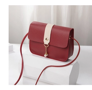Detail view of burgundy small crossbody bag with pearl charms and gold accents