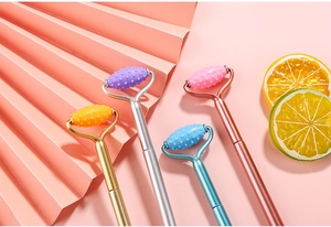 Macro shot of spiked massage rollers in gold, silver, blue, and rose gold with lemon accents